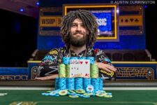 Ein junger Mann namens Caleb sitzt lächelnd an einem Pokertisch und hält Karten in der Hand. Er trägt ein dunkles Hemd und eine Brille. Im Hintergrund sind Pokerchips und andere