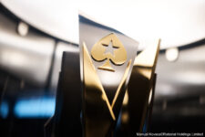 Ein glänzender Pokal in Gold und Silber auf einem schwarzen Sockel, der in einem leeren Raum steht.