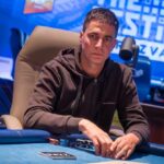 Ein Mann sitzt an einem Pokertisch während eines Turniers bei "The Festival Rozvadov Mixed Games Main Event" in Rozvadov. Er betrachtet konzentriert seine Karten.