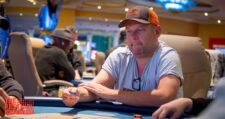 Ein Mann sitzt an einem Pokertisch während des "The Festival Rozvadov Mixed Games Main Event". Er hat eine Hand voll Spielkarten und konzentriert sich auf das Spiel.