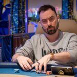 Ein Spieler nimmt am "The Festival Rozvadov Mixed Games Main Event" teil und sitzt an einem Pokertisch. Er hat eine Sonnenbrille auf und konzentriert sich auf seine Karten.