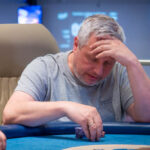 Ein Mann sitzt an einem Pokertisch während des "The Festival Rozvadov Mixed Games Main Event" im Kings Casino in Rozvadov. Der Mann hat einen Blick auf seine Karten und konzentriert sich auf das Spiel