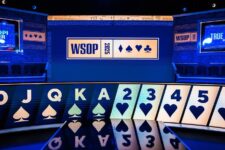 Ein Spieler beim World Series of Poker (WSOP) sitzt an einem Tisch und betrachtet seine Karten. Andere Spieler und der Dealer sind im Hintergrund zu sehen.